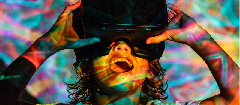 Amazed kid in VR headset under neon illumination